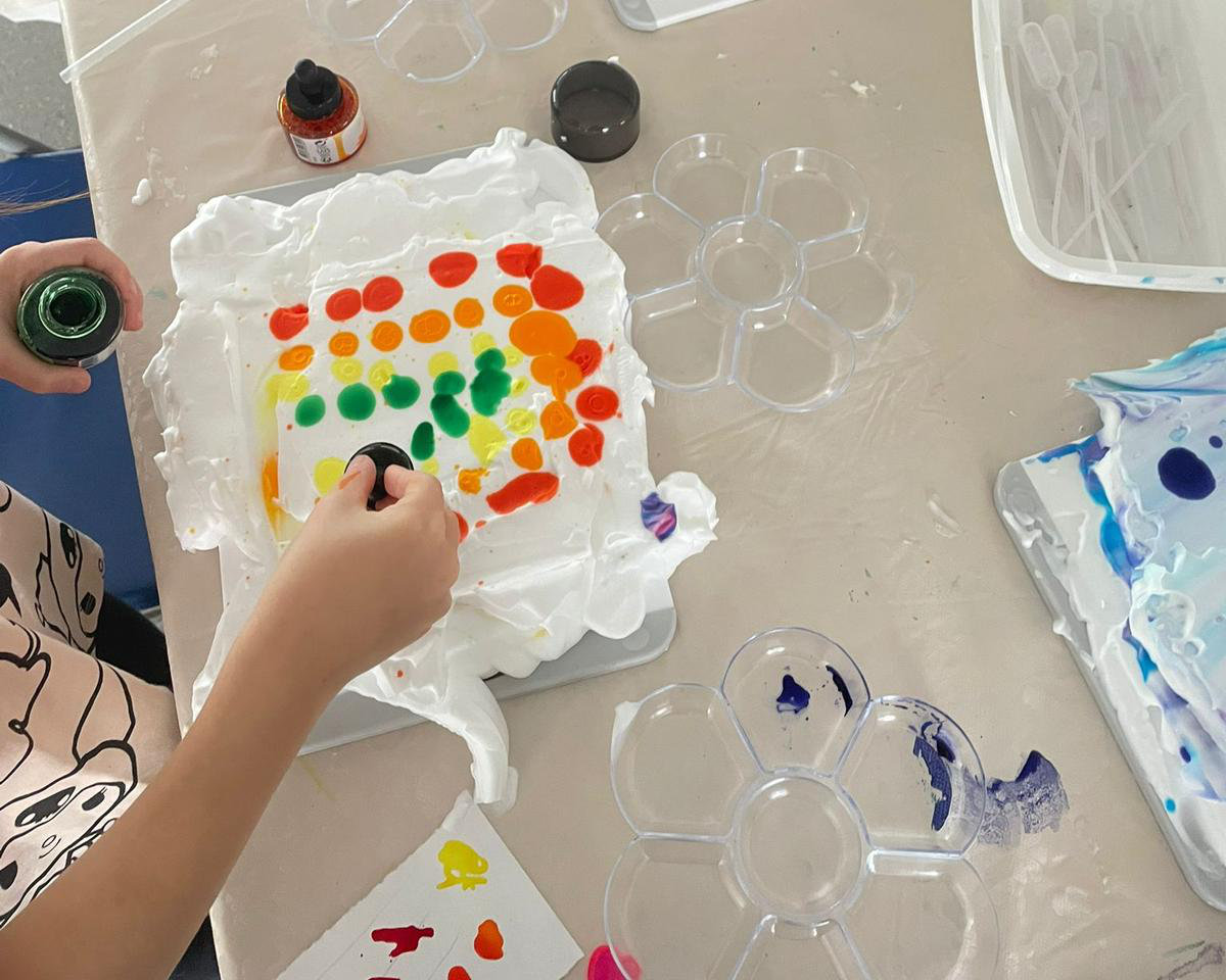 Enfant déposant des gouttes d'encre sur sa mousse à raser