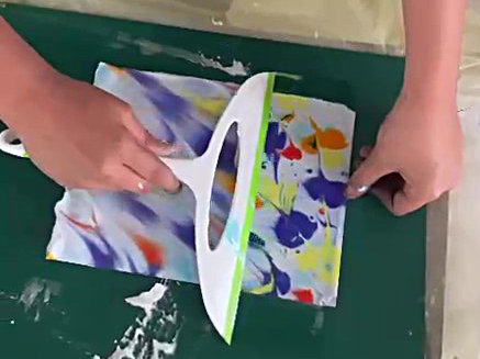 Mains d'enfant passant un coup de raclette pour enlever la mousse à raser de son papier