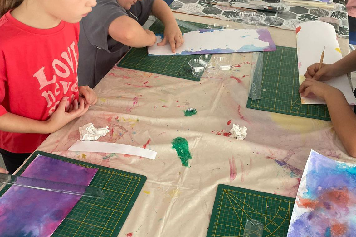 Enfants pliant leur longue bande de papier en accordéon